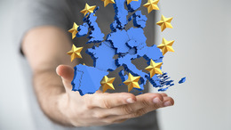 Auf einer Hand wird eine Darstellung der Europäischen Union hochgehalten